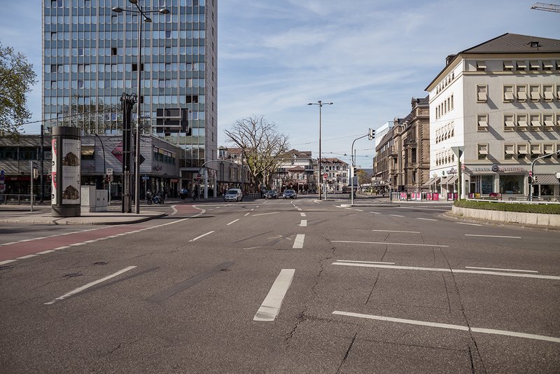 Heidelberg: Viel Raum für Verkehr in der Mitte, rechts Wohnbebauung aus verschiedenen Epochen mit angeglichener Traufhöhe, links Stil- und Höhenmix mit Hochhaus und Flachbau sowie dem Vorplatz des Theaters